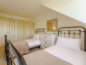 a bedroom with two beds and a dresser and a mirror at 5 Bed in Yarmouth 85286 in Yarmouth