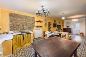 salon ze stołem i kamienną ścianą w obiekcie Suite il Corno w mieście Vidiciatico