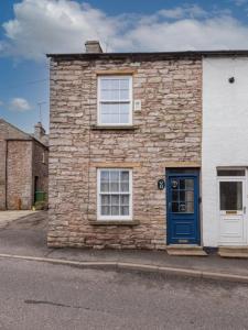 a stone building with a blue door on a street at 2 Bed in Kirkby Stephen SZ144 in Kirkby Stephen