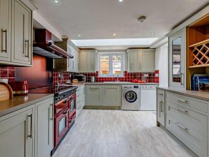 uma cozinha com armários brancos e uma máquina de lavar e secar roupa em 3 Bed in Bridport 85255 em Puncknowle