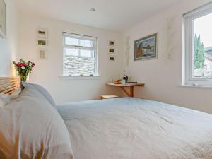 a white bedroom with a large bed and two windows at 2 Bed in Tarbert 85374 in Tarbert