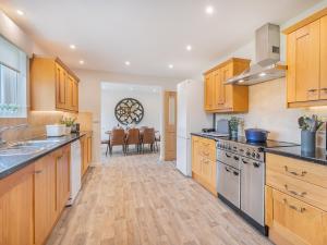 uma cozinha com armários de madeira e uma sala de jantar em 4 Bed in Eden Valley 85775 em Blencarn