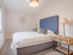 1 dormitorio con 1 cama grande y cabecero azul en 4 Bed in Eden Valley 85775 en Blencarn