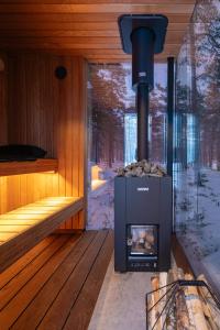 una chimenea en una sauna con nieve en el suelo en ÖÖD at Versso, en Pyhtaa