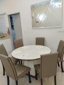 馬六甲的住宿－Amber Cove Leisure Homestay Melaka，一间配备有白色桌椅的用餐室