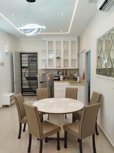 馬六甲的住宿－Amber Cove Leisure Homestay Melaka，厨房以及带桌椅的用餐室。