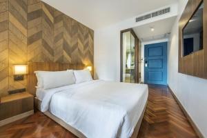 a bedroom with a white bed and a blue door at The poshtel Bangkok By Benya BTS Phayathai in Bangkok +67 photos