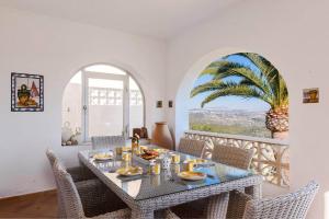 a dining room with a table and a palm tree at Villa Sabine - PlusHolidays in Calpe