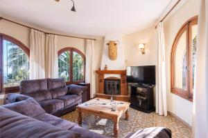 a living room with a couch and a fireplace at Villa Sabine - PlusHolidays in Calpe