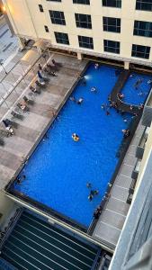 an overhead view of a large swimming pool with people in it at BV3 Studio Type with swimming pool in KK City Centre in Kota Kinabalu
