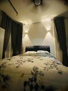 a bedroom with a bed with a floral comforter at IDAMAN HOMESTAY in Jasin
