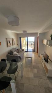 een woonkamer met een bank en een tv bij Apartamento en Altea con vistas al mar in Altea