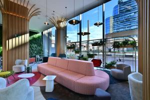 un vestíbulo con un sofá rosa y sillas en un edificio en Labtwentytwo Barcelona, a Tribute Portfolio Hotel en Barcelona