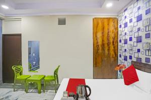 um quarto com cadeiras verdes e uma mesa num quarto em Hotel Metro Inn Near Worlds Of Wonder em Kālkāji Devi