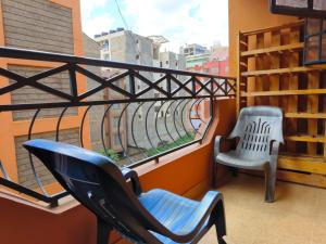 einen Balkon mit einem Stuhl und einem Fenster in der Unterkunft Trm homes in Nairobi