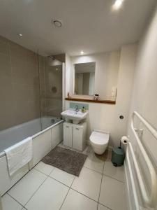 a bathroom with a sink and a toilet and a tub at 2BR/2BA Gem with Private Balcony in London