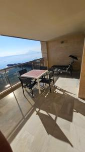 een tafel en stoelen op een balkon met uitzicht op de oceaan bij Apartamento en Altea con vistas al mar in Altea