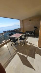 a table and chairs on a balcony with a view of the ocean at Apartamento en Altea con vistas al mar in Altea