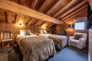 een slaapkamer met 2 bedden en een stoel in een kamer bij Chalet La Chaumière in Chamonix-Mont-Blanc