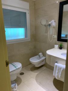 een badkamer met een wastafel, een toilet en een raam bij Hotel Villa San Francisco in Marbella