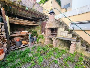 an outdoor kitchen with a brick oven next to a building at Dhh for fitters and craftsmen in Baden-Baden
