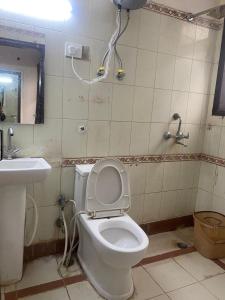 a bathroom with a white toilet and a sink at Hotel Jyoti Deluxe in New Delhi