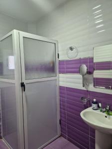 a purple bathroom with a shower and a sink at Dar Saphire Apartments in Chefchaouen