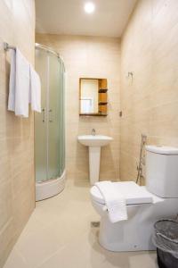 y baño con aseo, lavabo y ducha. en ELYSIUM HOTEL en Baku