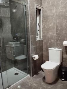 a bathroom with a toilet and a glass shower at Pearl Apartments in Sliema
