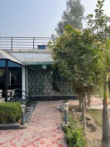 a building with a tree in front of it at The River Side Resort & Farm in Noida
