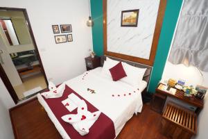 um quarto com uma cama com almofadas vermelhas e brancas em NT Elysian hotel em Hanói