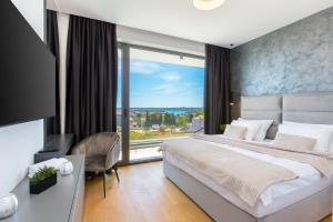 メドゥリンにあるLuxury Villa Dali with sauna, whirlpool and heated pool in Medulin only 1,7 km from the beachの大きなベッドと大きな窓のある寝室