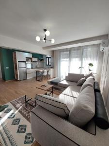 a living room with a couch and a kitchen at BeHOME in Tirana