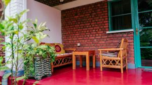 patio con mesa, sillas y pared de ladrillo en Isange Paradise Resort en Ruhengeri