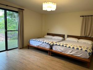 a bedroom with two beds and a large window at Xianyan Villa B&B in Sanyi
