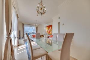 jadalnia ze szklanym stołem i krzesłami w obiekcie Apartamento Marbella Playa w Marbelli
