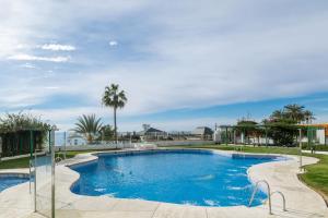 basen z błękitną wodą i palmami w obiekcie Apartamento Marbella Playa w Marbelli
