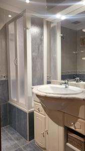 a bathroom with a sink and a large mirror at Apartamentos Terrasol Plazamar in Torre del Mar