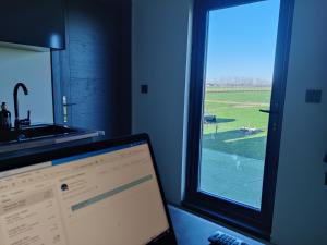 a laptop computer sitting on a desk next to a window at Tiny House Betuwe in Tricht