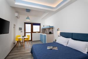 a bedroom with a blue bed and a kitchen at OlbiaLoft in Olbia