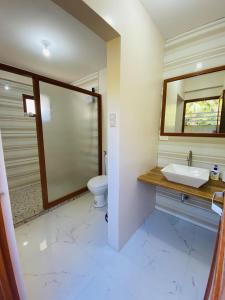 a bathroom with a sink and a toilet at Birbeck Lodge in Bulusan