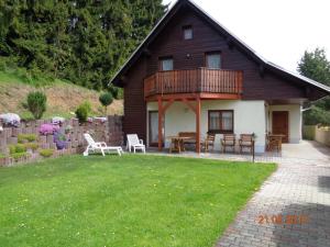 ein Haus mit einer Terrasse, einem Tisch und Stühlen in der Unterkunft Ferienhaus Bauer in Kurort Oberwiesenthal