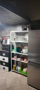 a kitchen with a refrigerator and an open pantry at DAR LAAZIZA in Meknès
