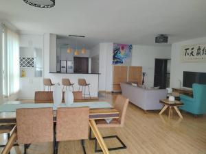 een keuken en een woonkamer met een tafel en stoelen bij Soho 顶层豪华复式 in Nairobi