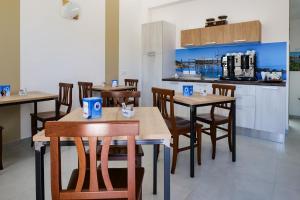 a restaurant with wooden tables and chairs and a kitchen at Villa Caravaggio Comfort e Relax in Rocca San Giovanni