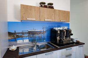 a kitchen with a sink and a pier painted on the wall at Villa Caravaggio Comfort e Relax in Rocca San Giovanni