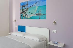 a bedroom with a bed and a painting on the wall at Villa Caravaggio Comfort e Relax in Rocca San Giovanni