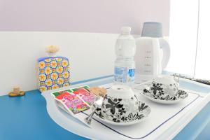 a white table with two cups and a bottle of water at Villa Caravaggio Comfort e Relax in Rocca San Giovanni