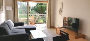 a living room with a couch and a flat screen tv at Encosta Da Orada in Albufeira
