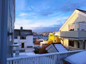 uma vista a partir de uma varanda de edifícios com neve em Ksu Nordlandet leiligheten em Kristiansund